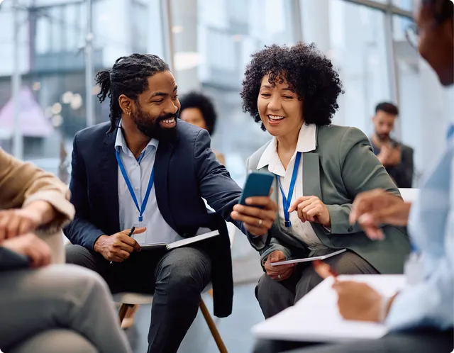 Colleagues looking at a smartphone in a modern office